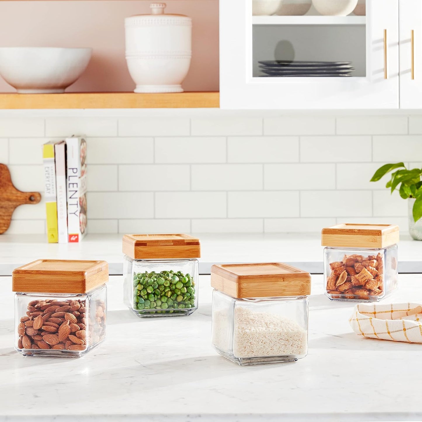 Glass storage jars with wooden lids on a kitchen counter