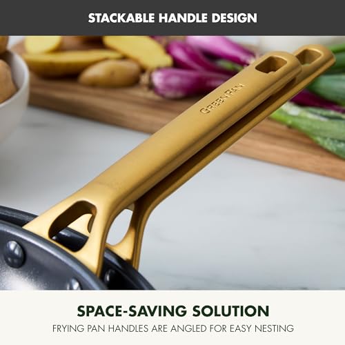 Gold handle of a frying pan with vegetables on a cutting board in the background