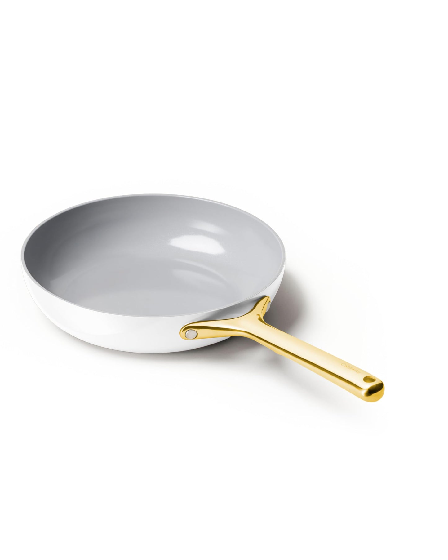 White frying pan with a gold handle on a white background