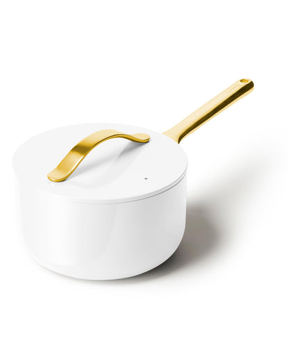White saucepan with a gold handle on a white background