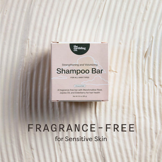 The Earthling Co. shampoo bar packaging on a textured beige background with 'Fragrance-Free' text.