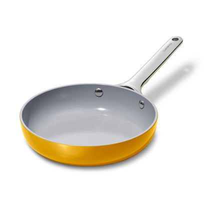 Frying pan with yellow exterior and gray interior on a white background