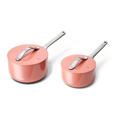 Two pink cookware items with silver handles on a white background