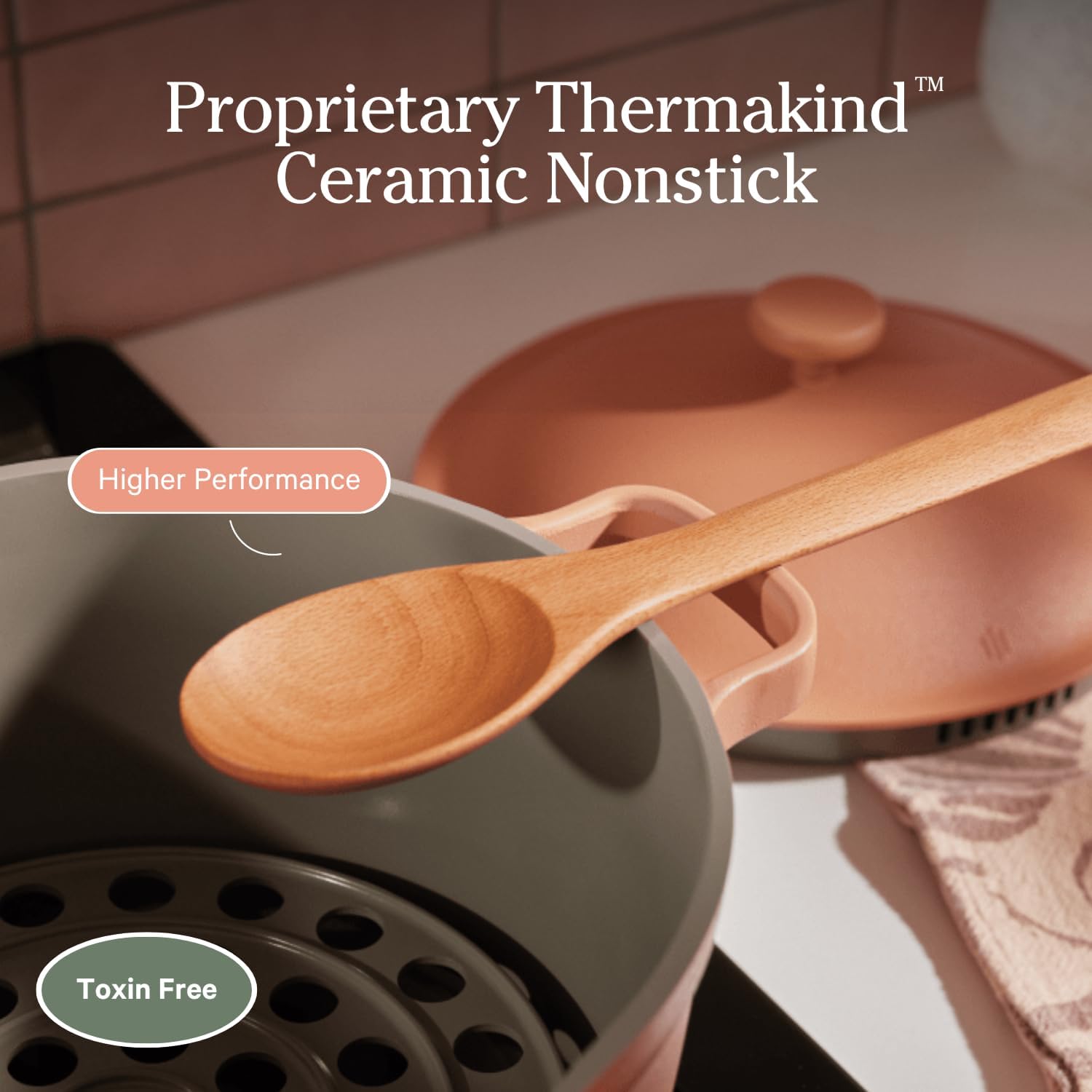 Ceramic nonstick cookware set with wooden spoon on a kitchen counter