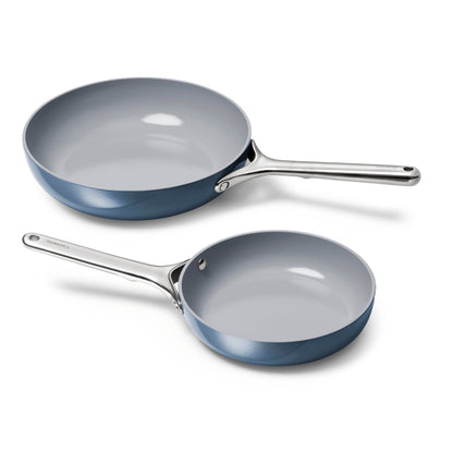 Two blue ceramic cookware pans on a white background