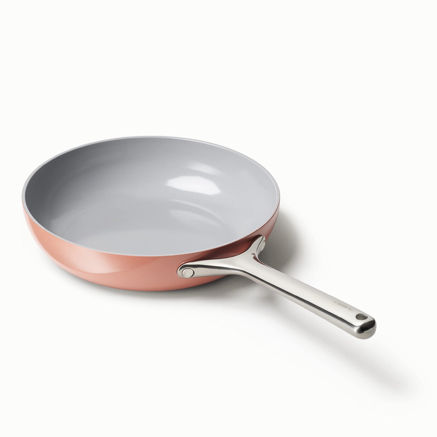Frying pan with pink exterior and silver handle on a white background