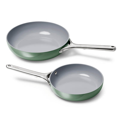 Two green frying pans on a white background