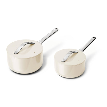 Two cream-colored cookware pots with silver handles on a white background