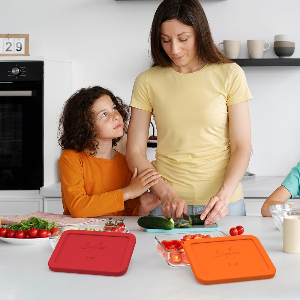 Woman and child preparing vegetables in a kitchen with colorful cutting boards.