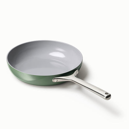 Green frying pan with a silver handle on a white background