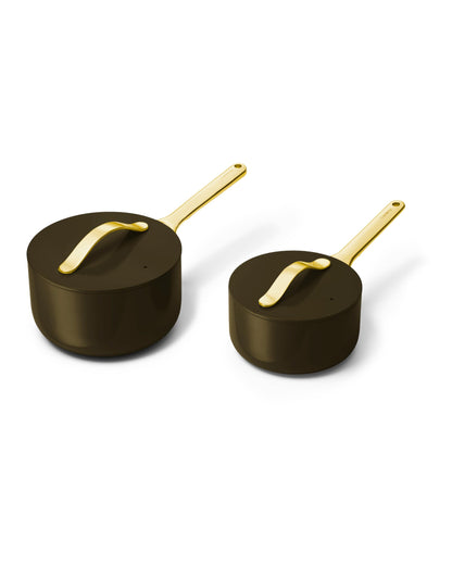 Two black pots with gold handles on a white background