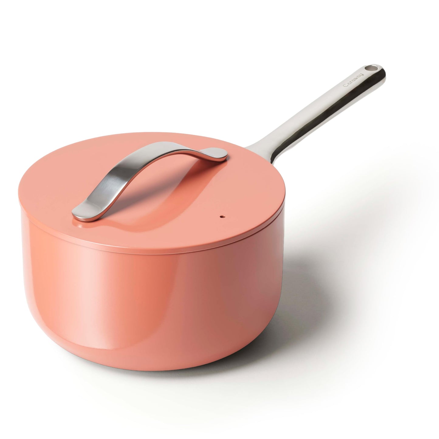 Coral-colored saucepan with a silver handle on a white background