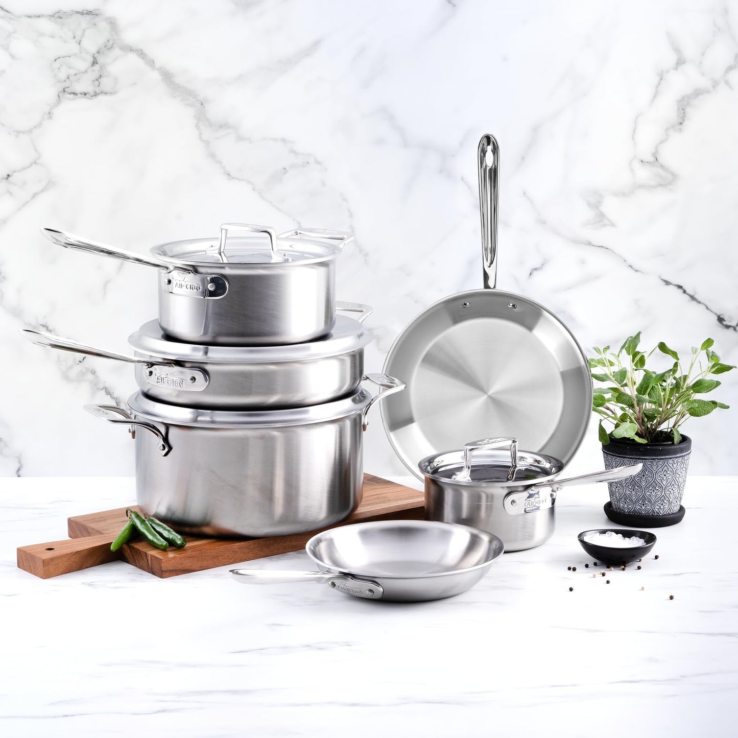 Set of stainless steel cookware on a marble countertop