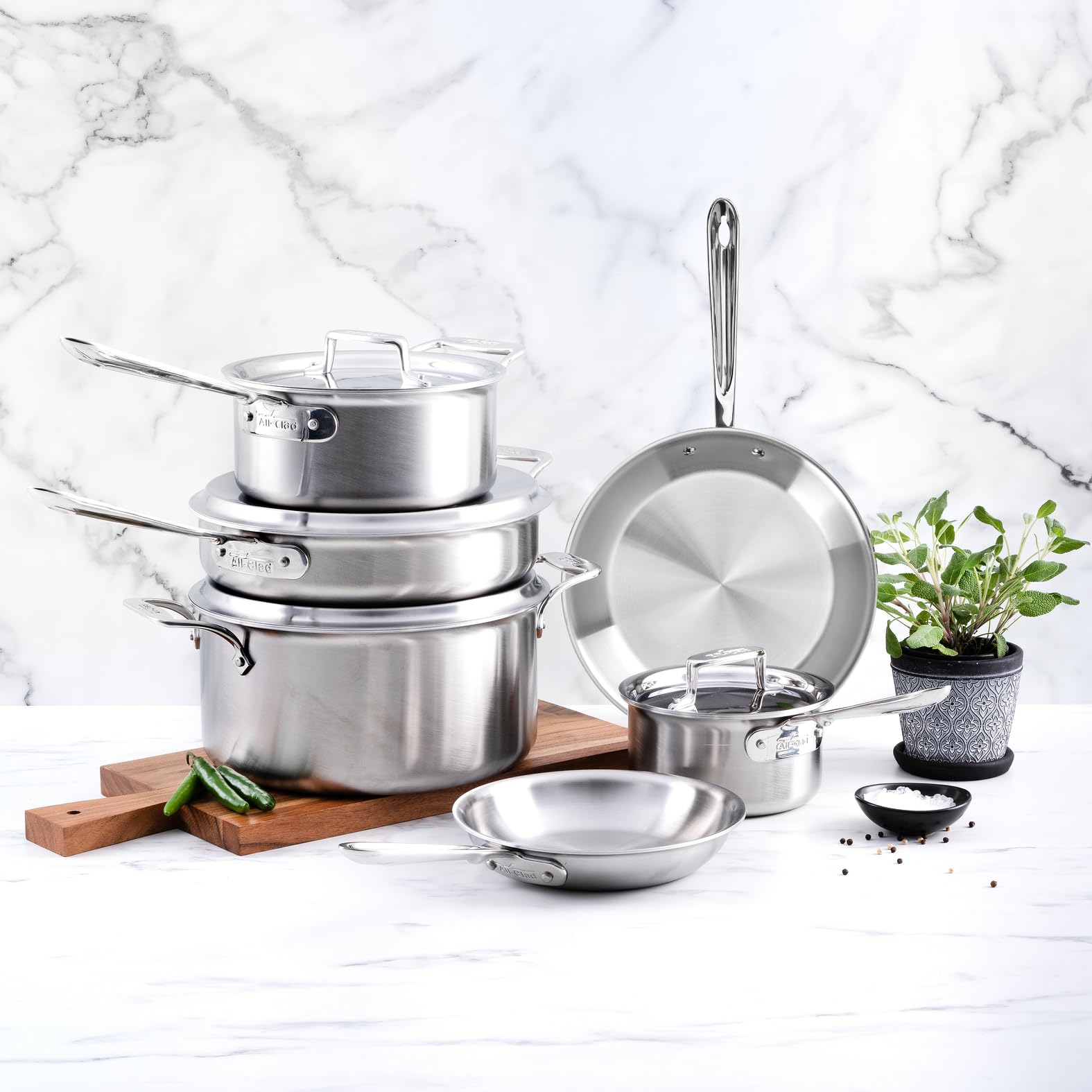 Set of stainless steel cookware on a marble countertop
