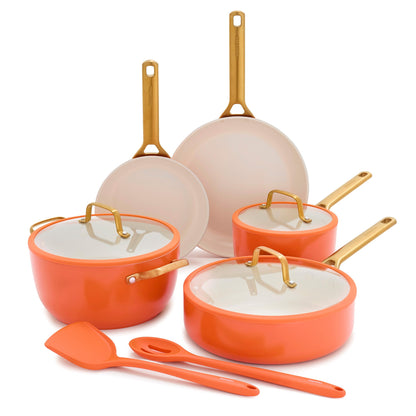 Set of orange and beige cookware with gold handles on a white background