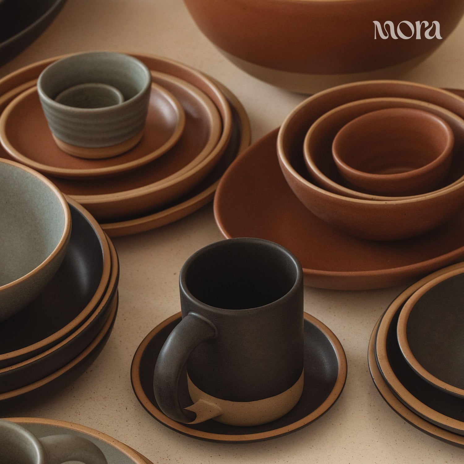 Mora Medium Ceramic Bowls including  cups, and saucers on a neutral background.