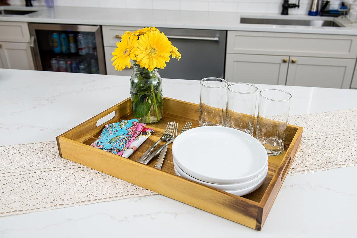 Lipper International Acacia Wood Serving Tray with Handles with plates, glasses, and flowers on a kitchen counter