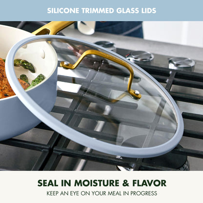 Glass lid with silicone trim on a stove, showing food inside.