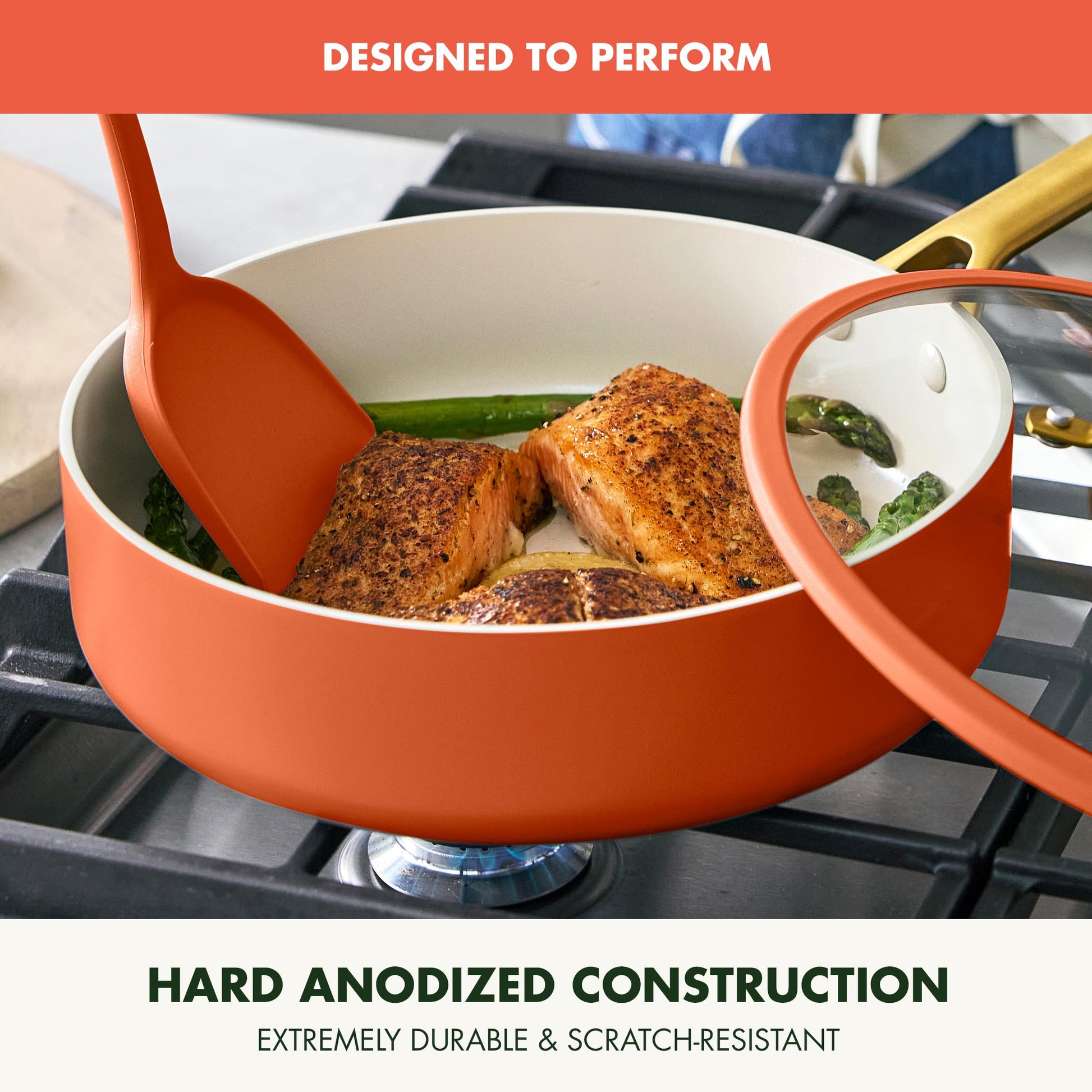 Orange cookware set with food on a stove, featuring text about hard anodized construction.