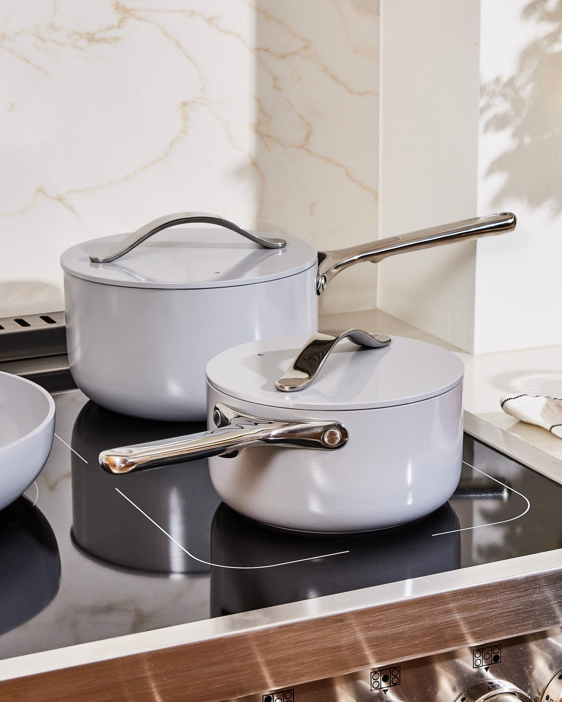 Set of ceramic cookware with lids on a stove