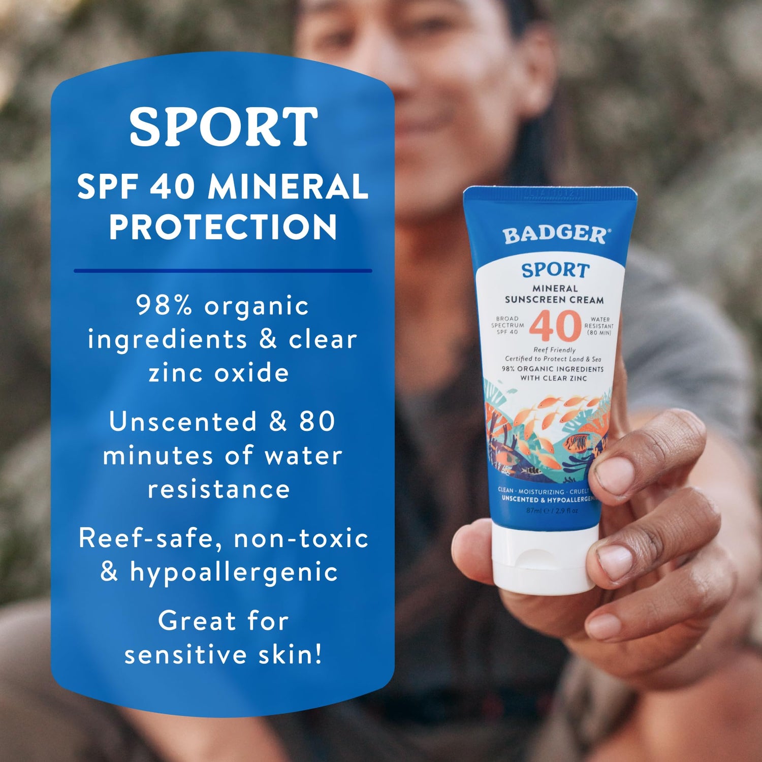 Person holding a Badger Sport sunscreen cream with product details on a blue background