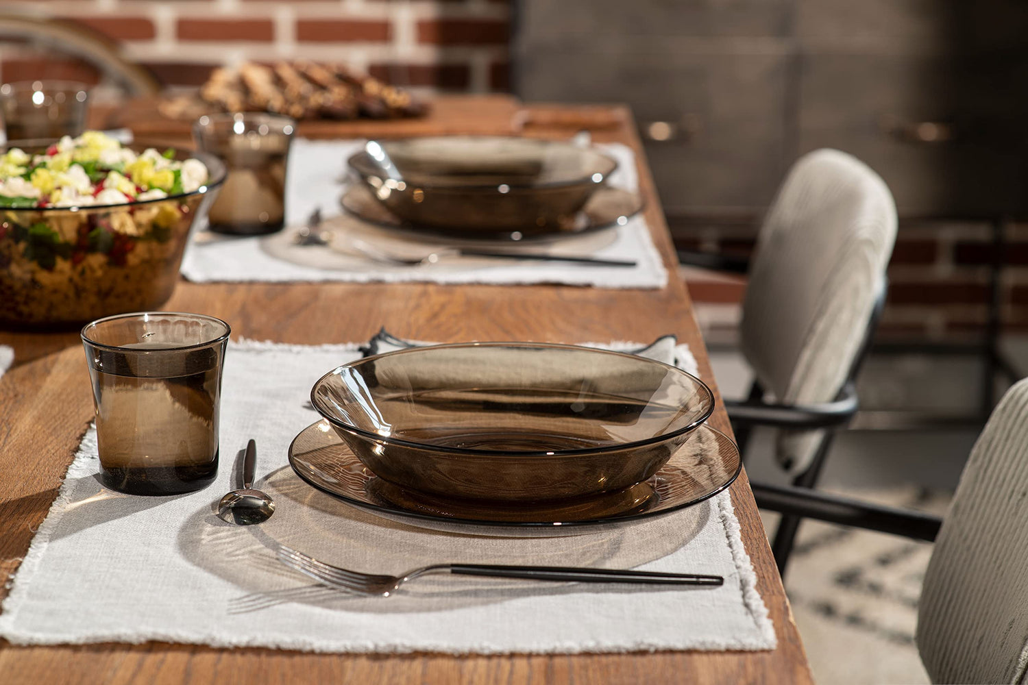 Duralex Lys Glass Dinnerware set with plates, glasses, and cutlery on a wooden table.