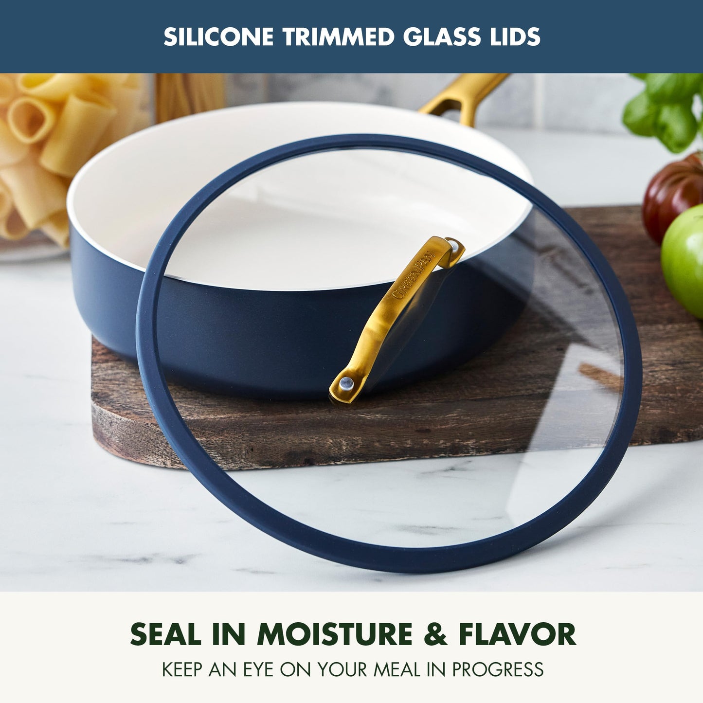 Blue ceramic dish with silicone lid on a marble surface, surrounded by kitchen items.