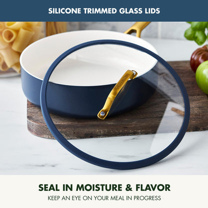 Blue ceramic dish with silicone lid on a marble surface, surrounded by kitchen items.