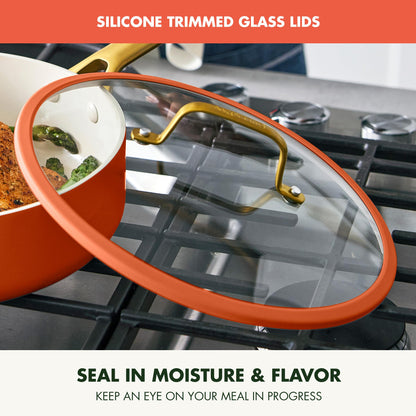 Ceramic pot with glass lid on a stove, featuring silicone trim.