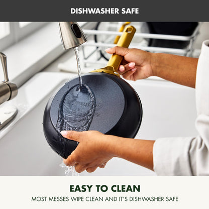 Person rinsing a black frying pan under running water with text indicating dishwasher safety and ease of cleaning.