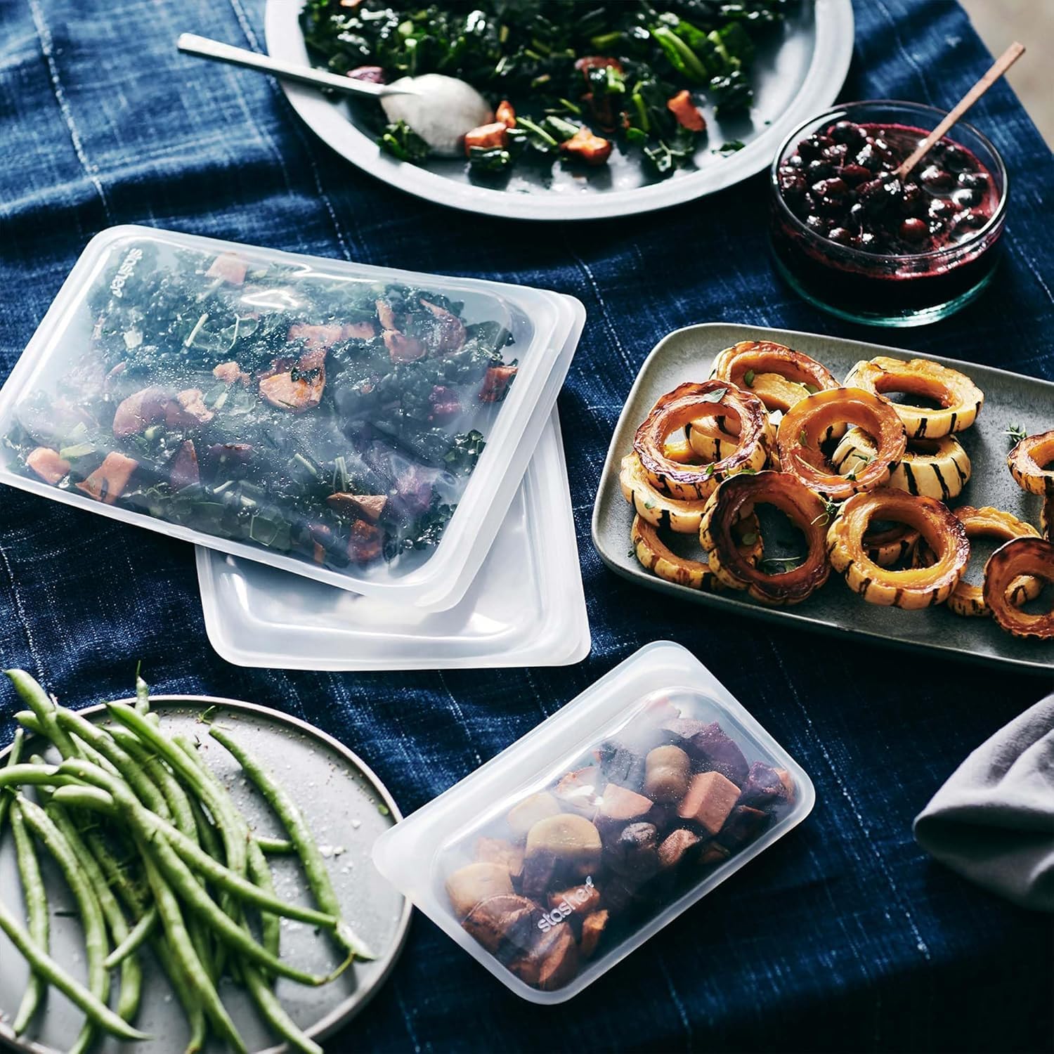 Prepared meals in silicon containers on a blue checkered tablecloth