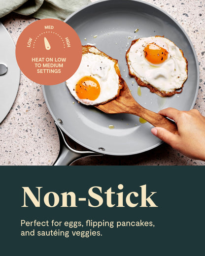 Non-stick frying pan with two fried eggs on a kitchen counter