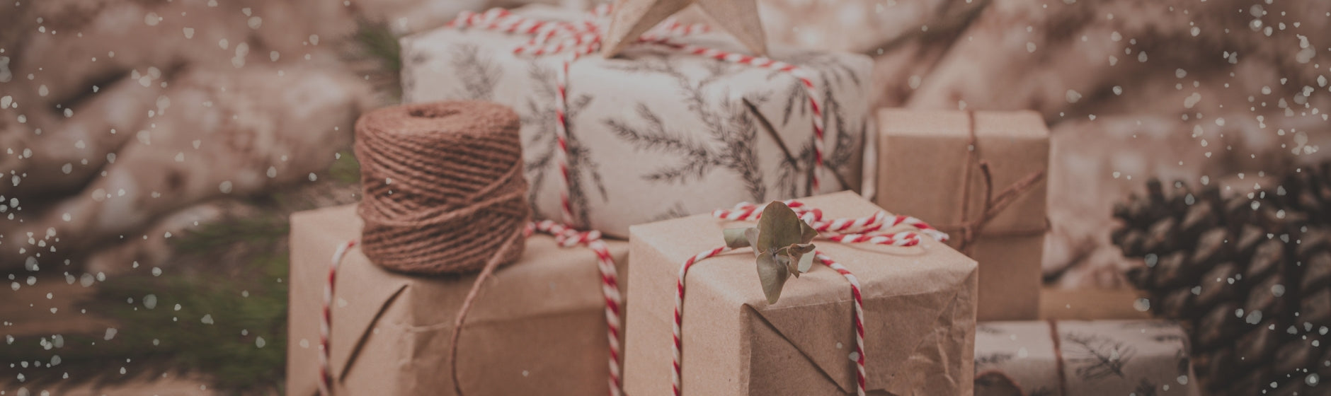 Decorative Christmas scene with wrapped gifts and pinecones on a snowy background